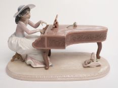 Lladro figure of a lady playing a grand piano, H21 x L34cm