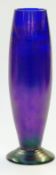 An iridescent blue glass pedestal vase with remnants of gilt decoration, 32cm tall