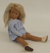 Sasha doll with pink lips, blue eyes, blue eyeshadow, blonde hair, check outfit and leather shoes,