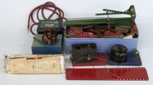 A collection of Meccano parts including a transformer and controller