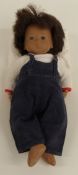 Sasha doll with pink lips, brown eyes, blue eyeshadow, brown hair, blue dungarees and white top,