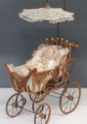 A childs dolls pram, with wicker basket and lace parasol together with three dolls and a Teddy Bear