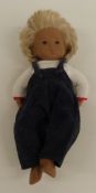 Sasha doll with pink lips, brown eyes, blue eyeshadow, blonde hair, blue dungarees and white top,