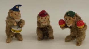 A set of three M Toys of West German clockwork mohair covered tinplate monkeys, all in the form of a