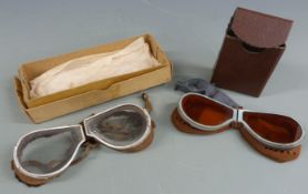 Two pairs of folding goggles, one with tinted lenses and leather backed surround, both with box /