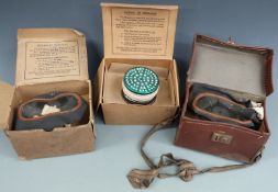 Three WWII gas masks on in leather carry case