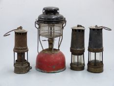 Three vintage miners lamps and a Tilley lamp