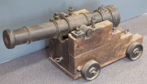 A cast iron cannon with lions head touch hole and 43 inch graduated multi-stage barrel on wooden