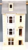 A three storey dolls house with attic with hinged door and lift up roof, wired for battery powered