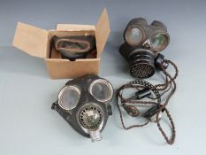 WWII three respirators comprising a child's boxed example, one with a radio operator's headphone