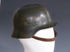 German Army WWII steel helmet with single decal to side, stamped SE62 complete with leather liner