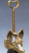 A 19thC brass door stop/porter in the form of a fox's head with riding crop handle, H35cm