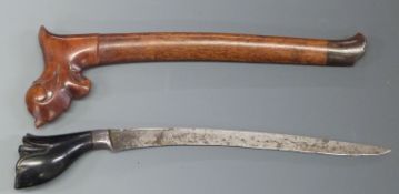 A Polynesian / Kris style dagger with 22cm blade, in carved wooden scabbard.