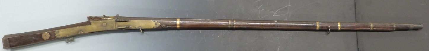 Middle Eastern matchlock gun with brass lock and butt plates stamped with circular decoration, brass