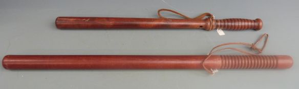 Two American police truncheons, one 55cm the other 66cm, both with leather straps