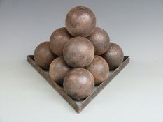 Ten cast iron cannon balls on a cast iron monkey, each approximately 10cm in diameter