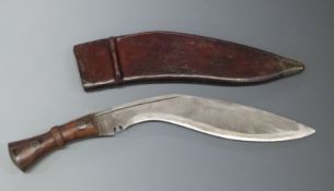 Kukri knife with 31cm curved blade, in leather sheath stamped 1945.