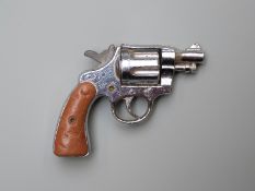 Miniature percussion hammer action single shot revolver cap gun with chequered grips, 6.4cm long.