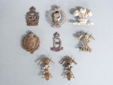 A small collection of British Army cap badges including 18th Hussars, 22nd Dragoons and 21st