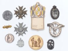 A quantity of WWII German badges and medallions and a possibly post-war pilot's badge