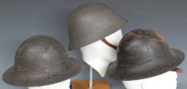 Two Civil Defence helmets and a similar more modern example