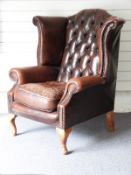 Leather Chesterfield wing backed armchair. W86 x H107cm