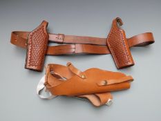 Three brown leather pistol/revolver holsters including one pair with embossed decoration with two