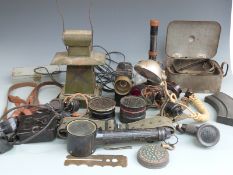 A collection of military equipment including signalling lamps, respirator canister, rifle sights,
