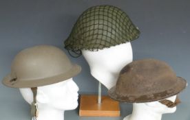 Two Brodie steel helmets, one with W (Warden) to front together with a more modern example
