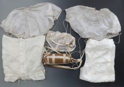 A small packed parachute with attached drag chute, together with two small parachutes and a set of