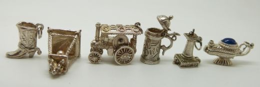 Six silver charms including a steam engine, sun dial, lamps,  etc