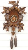 Black Forest German two train cuckoo clock with carved woodpecker decoration, 45cm tall