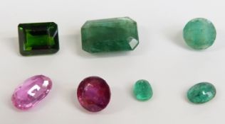 An emerald cut emerald, two oval cut emeralds and a round cut emerald, an emerald cut tourmaline,