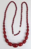 A cherry amber necklace of 77 graduated oval beads, the largest 35.6x27.1mm, 144g.