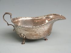 George VI hallmarked silver sauce boat with shaped edge, raised on three feet, Birmingham 1942 maker