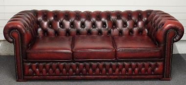 A red leather three seat Chesterfield sofa, length 206cm