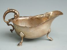George VI hallmarked silver sauce boat raised on three feet with scroll handle, Birmingham 1940