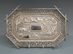 Indian, Burmese or similar white metal tray having central embossed scene of animals and buildings