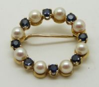 A 9ct gold brooch set with alternating pearls and sapphires, 2.2cm diameter