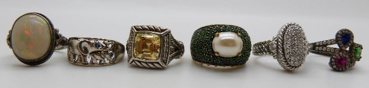 A silver ring depicting elephants set with sapphire eyes, a silver ring set with a ruby, sapphire,