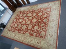 Large red and beige ground rug with stylised floral design 490 x 364cm