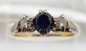An 18ct gold ring set with a sapphire and two diamonds in a platinum setting, 2.6g, size M
