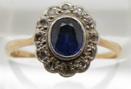 An 18ct gold ring set with an oval sapphire surrounded by diamonds, 1.9g, size M