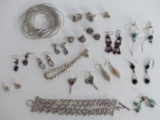 A silver bracelet made up of multiple bangles, silver earrings, two silver bracelets, silver and