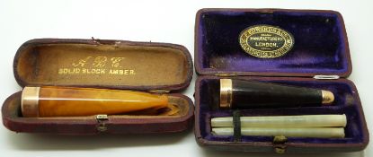 Two cheroot holders, one set with amber both with 15ct gold collars, in original boxes (Birmingham