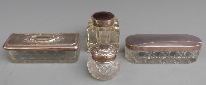 Three hallmarked silver lidded cut glass dressing table pots, length of longest 11cm, and a