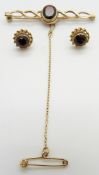A 9ct gold brooch and earrings set with a garnet to each, 6g