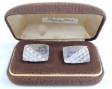 A pair of silver cufflinks with engraved decoration in original box