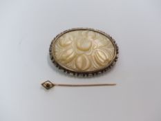 A 9ct gold stick pin and a silver brooch set with carved mother of pearl