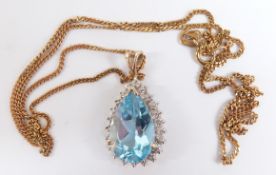 A 9ct gold pendant set with a pear cut topaz surrounded by diamonds, 4.4g